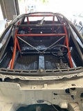 Interior view of a vehicle showing a metal roll cage structure, presumably part of a car's conversion kit to upgrade the roll cage from 6-point to 10-point. ONLY A-pillers and roof bar included in this kit.